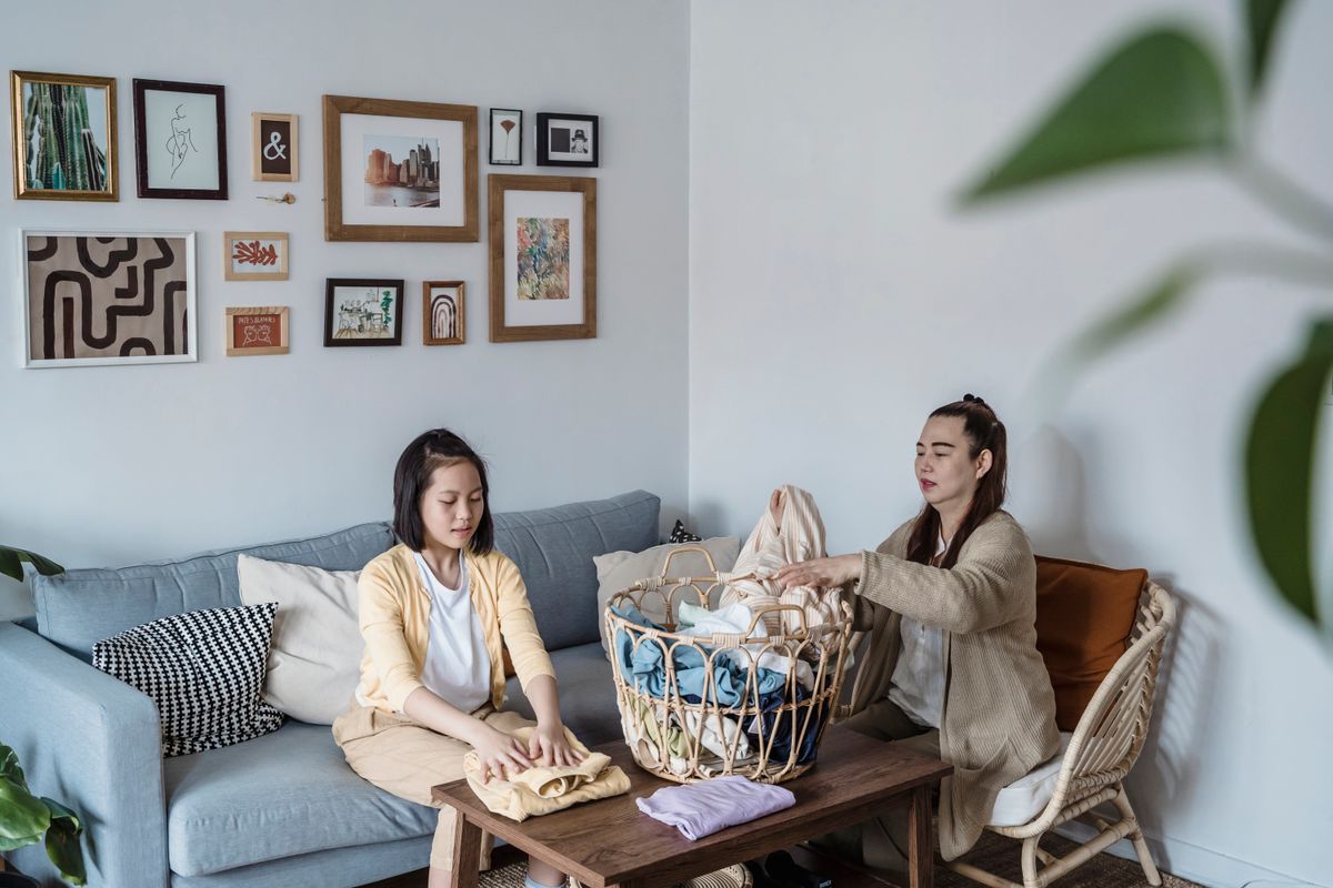 Photo by Annushka Ahuja on Pexels Eine Mutter und ihre Tochter sind damit beschäftigt, auf einem bequemen Sofa Wäsche zusammenzulegen und so den Familienzusammenhalt zu stärken. - Foto von Annushka Ahuja auf Pexels