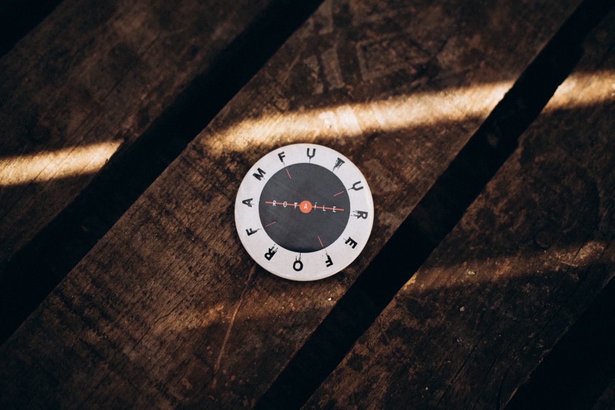 Circular disk on a rustic wooden table with sunlight casting shadows. Circular disk on a rustic wooden table with sunlight casting shadows.
