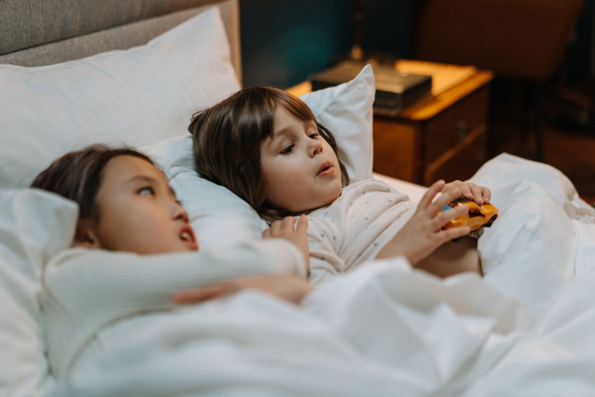 Photo by cottonbro studio on Pexels Zwei Kinder im Bett spielen mit einem Spielzeugauto und genießen einen gemütlichen Moment drinnen. - Foto von Cottonbro Studio auf Pexels