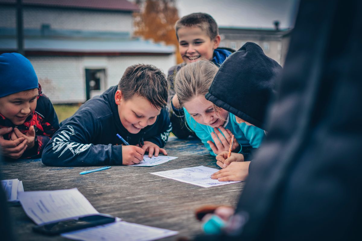 Photo by Kirill Ozerov on Pexels Happy children drawing together outdoors on a wooden table, fostering creativity and teamwork. - Photo by Kirill Ozerov on Pexels