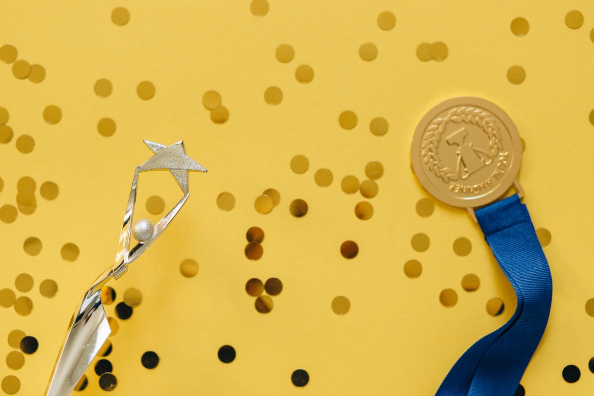 Photo by Nataliya Vaitkevich on Pexels A medal and small reward objects on a bright surface - Photo by Nataliya Vaitkevich on Pexels