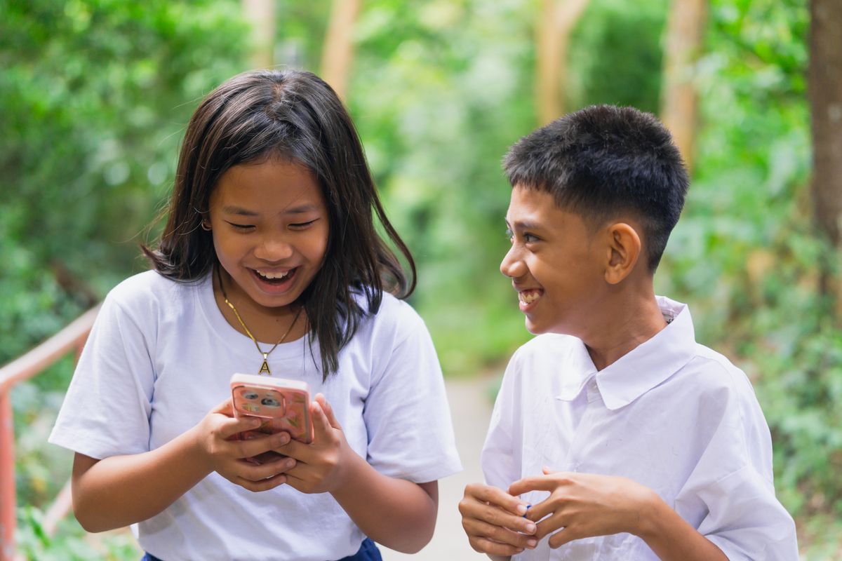 Photo by Nothing Ahead on Pexels Zwei glückliche Kinder genießen gemeinsam ein Smartphone in einer üppigen Umgebung im Freien. - Foto von Nothing Ahead auf Pexels