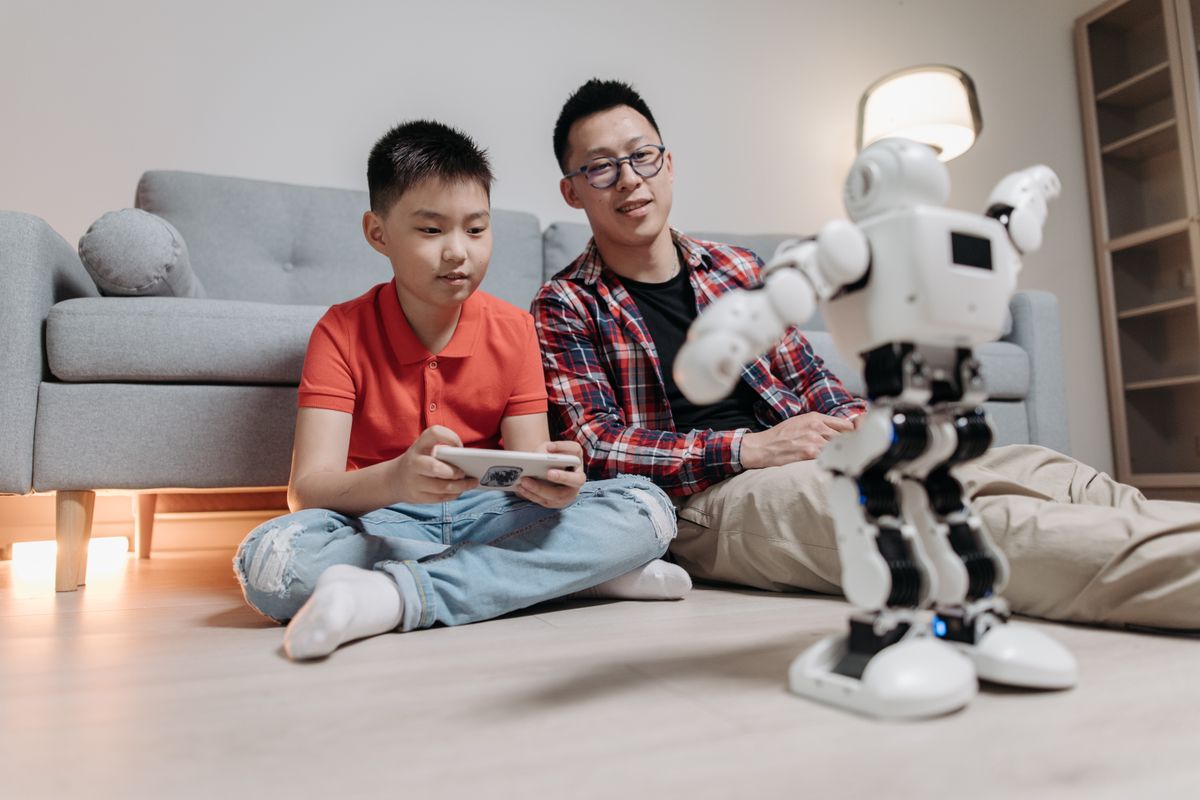 Photo by Pavel Danilyuk on Pexels Ein Vater und sein Sohn freunden sich an, während sie drinnen mit einem Roboter und einer Fernbedienung spielen. - Foto von Pavel Danilyuk auf Pexels