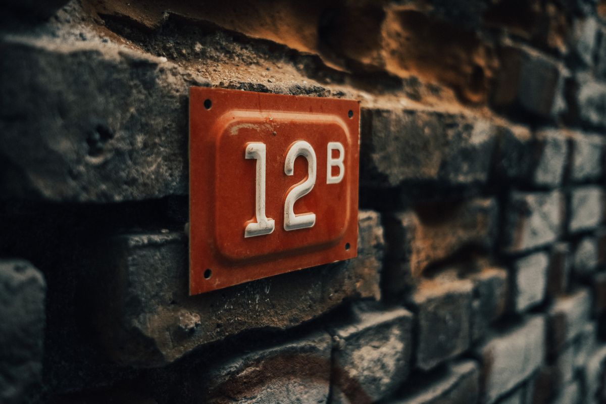 Photo by Sami Aksu on Pexels Close-up of a vintage apartment number 12B on a textured stone wall. - Photo by Sami Aksu on Pexels