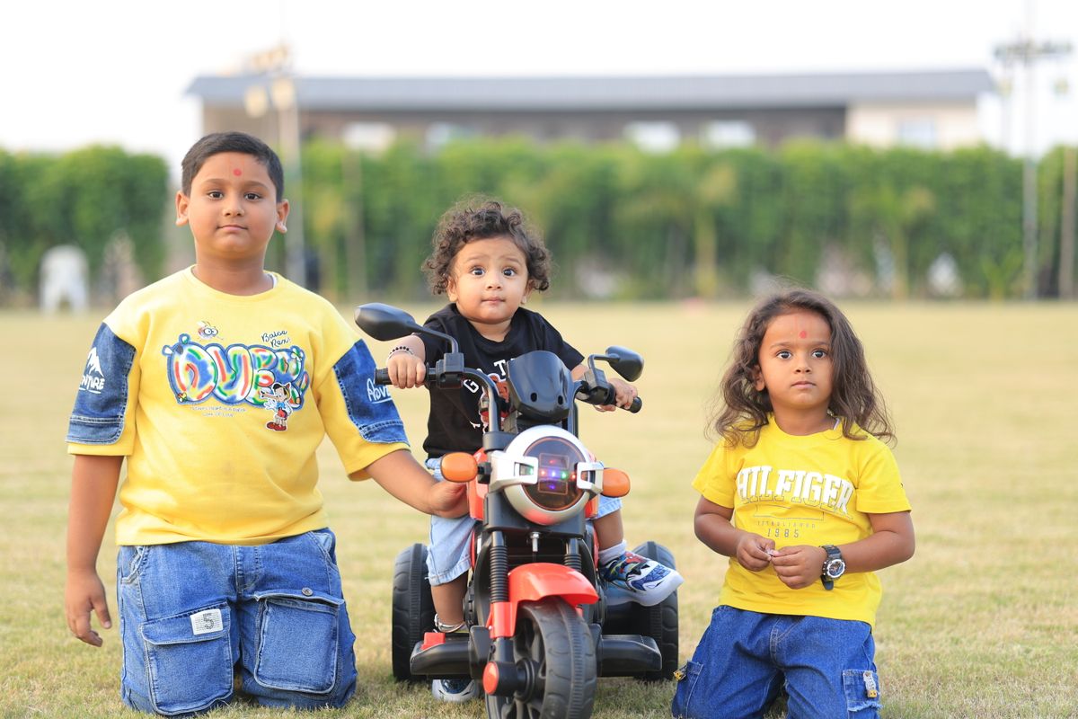 Photo by the Amritdev on Pexels Three children enjoying outdoor play with a toy bike, capturing joyful childhood moments. - Photo by the Amritdev on Pexels