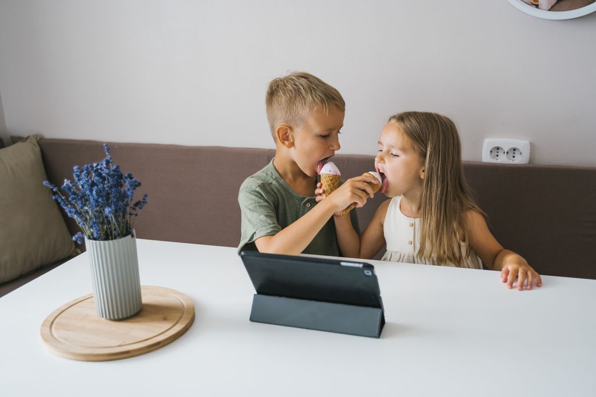 Photo by Tima Miroshnichenko on Pexels Zwei Kinder teilen sich glücklich eine Eistüte in einem gemütlichen Innenbereich. - Foto von Tima Miroshnichenko auf Pexels