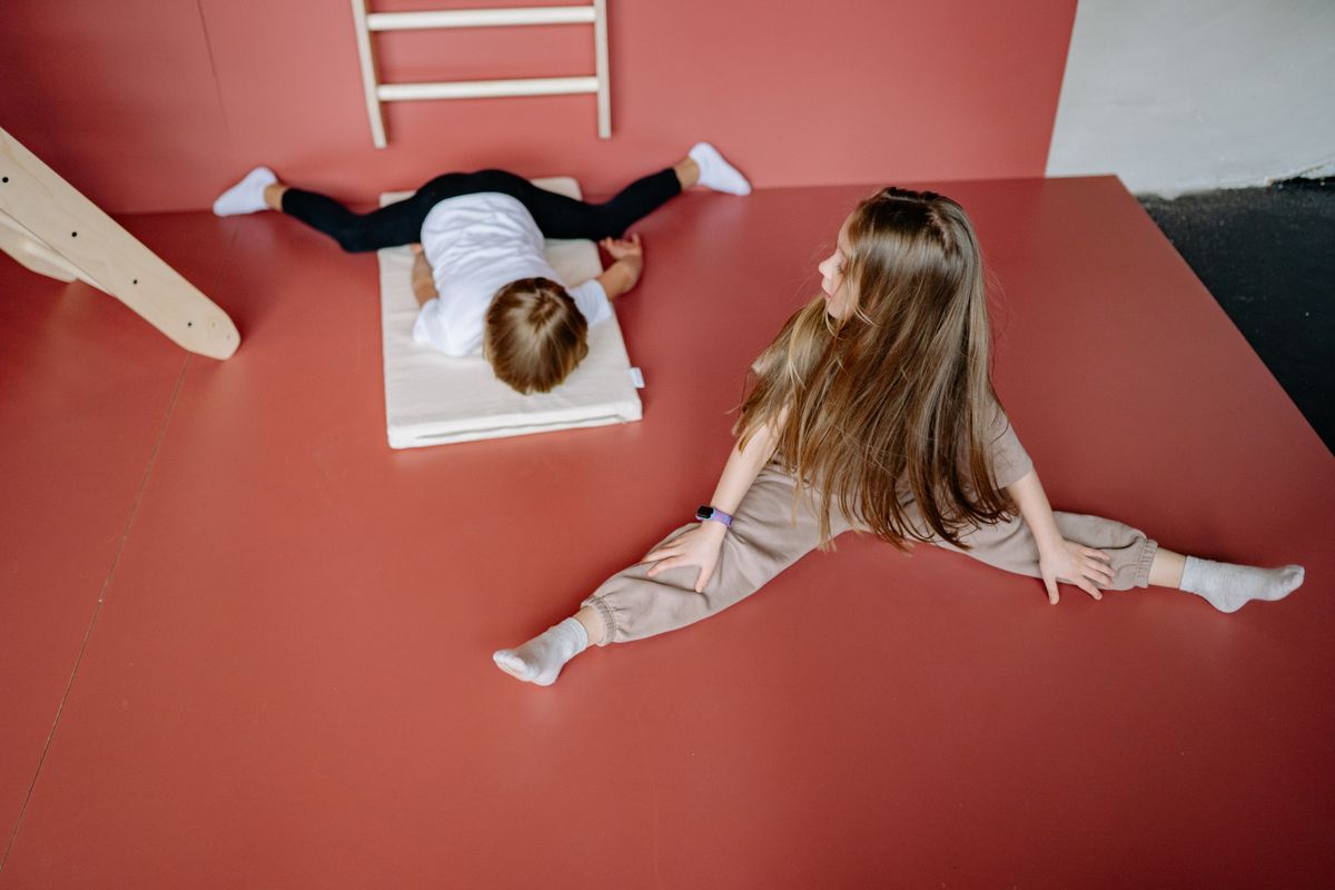 Photo by Yan Krukau on Pexels Two children engaging in gymnastics on a mat indoors, showcasing flexibility and playfulness. - Photo by Yan Krukau on Pexels