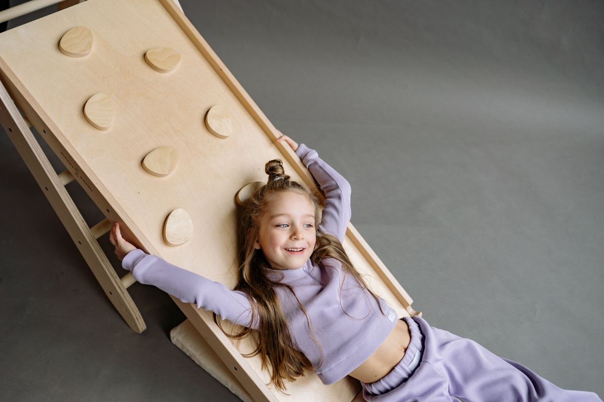 Photo by Yan Krukau on Pexels A joyful child enjoying playtime on a wooden climbing frame indoors. - Photo by Yan Krukau on Pexels