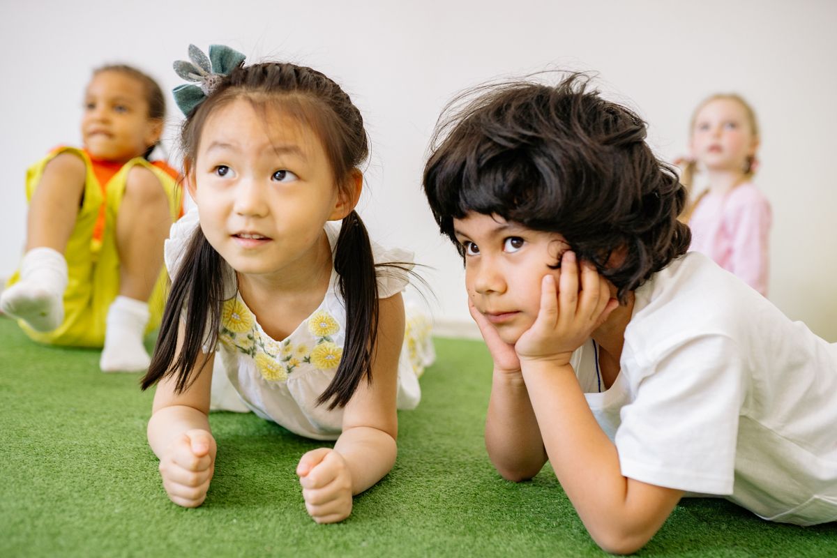 Photo by Yan Krukau on Pexels Gruppe von Kindern, die drinnen auf Gras liegen und eine spielerische Lernaktivität im Kindergarten genießen. - Foto von Yan Krukau auf Pexels