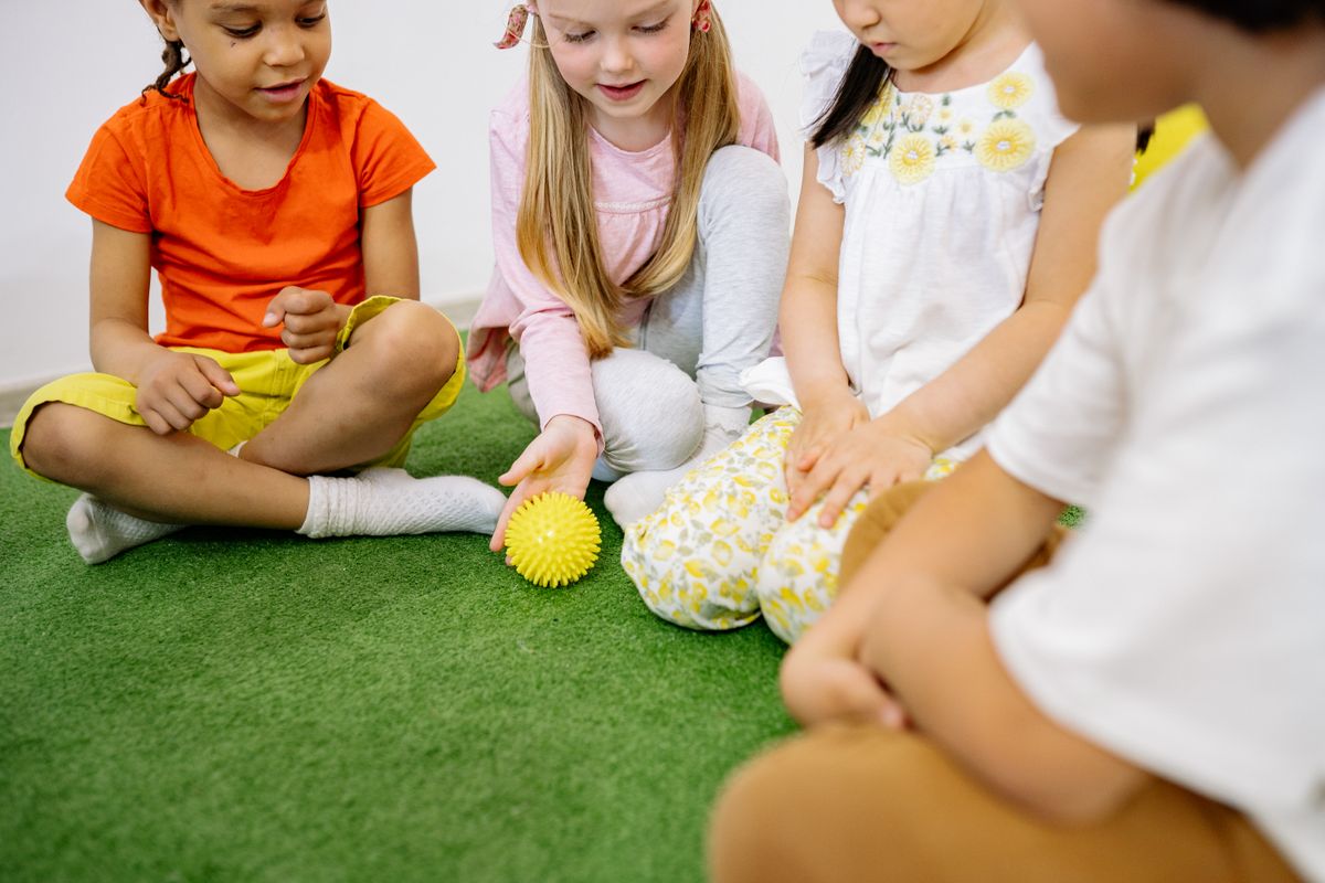 Photo by Yan Krukau on Pexels Glückliche, vielfältige Kinder, die gemeinsam drinnen mit einem gelben Ball spielen. - Foto von Yan Krukau auf Pexels
